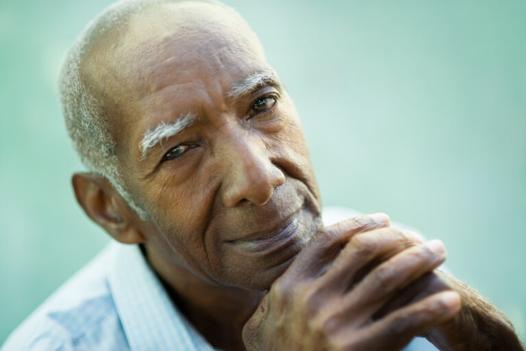 older man with hands at his chin