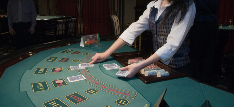 casino dealer at table with cards